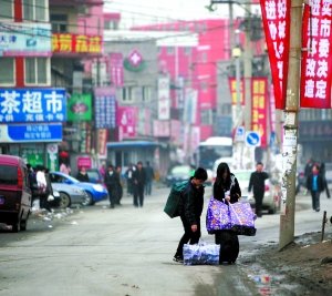 3月31日,唐家岭中街,两个年轻人提着行李搬家。随着拆迁消息的确认,越来越多的大学毕业生们陆续离开唐家岭,寻找新的居住地。