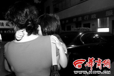 26日晚,在土门派出所里,唐女士抱着女儿在等丈夫出来。之前发生的冲突让母女俩心惊胆战 本报记者 雷佳摄