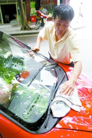 邓浩细心擦洗心爱的三轮摩托车。