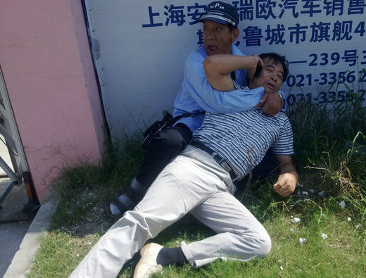 企图逃跑的奥迪车司机被一男性协管员扑倒并紧紧抱住后,仍挣扎着打电话告知“闯祸了”。 企图逃跑的奥迪车司机被一男性协管员扑倒并紧紧抱住后,仍挣扎着打电话告知“闯祸了”。